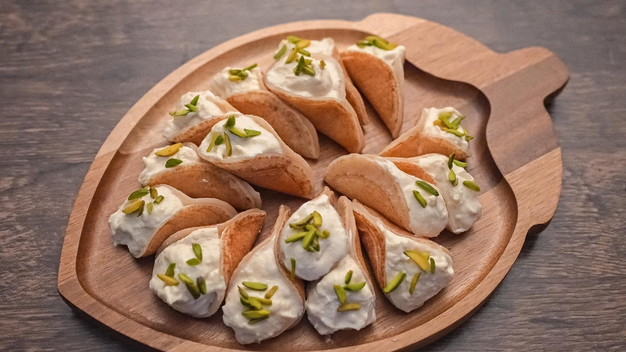 Assorted filled pastries arranged on a wooden serving platter