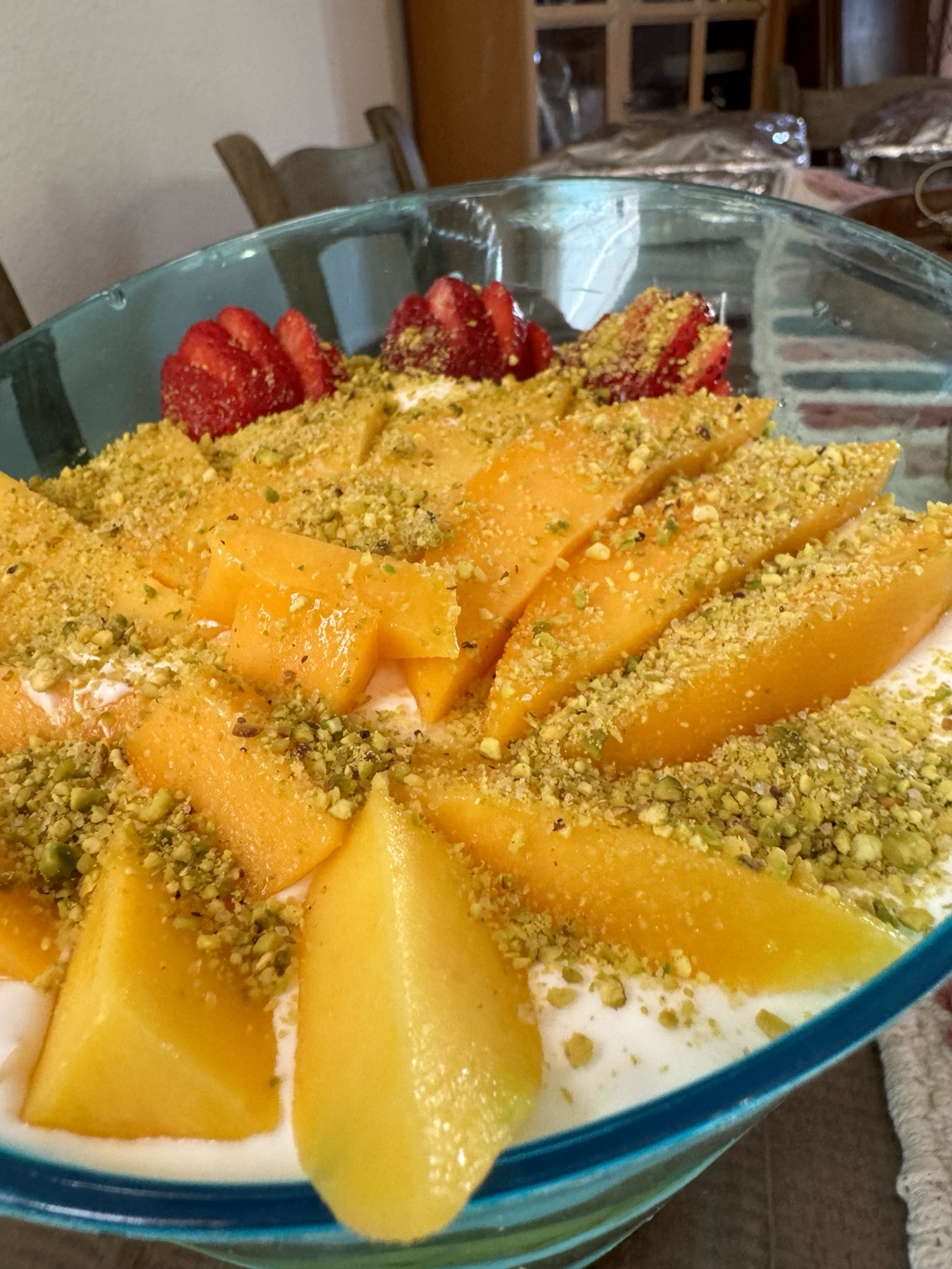 Fruit dessert served in a bowl with pistachio topping