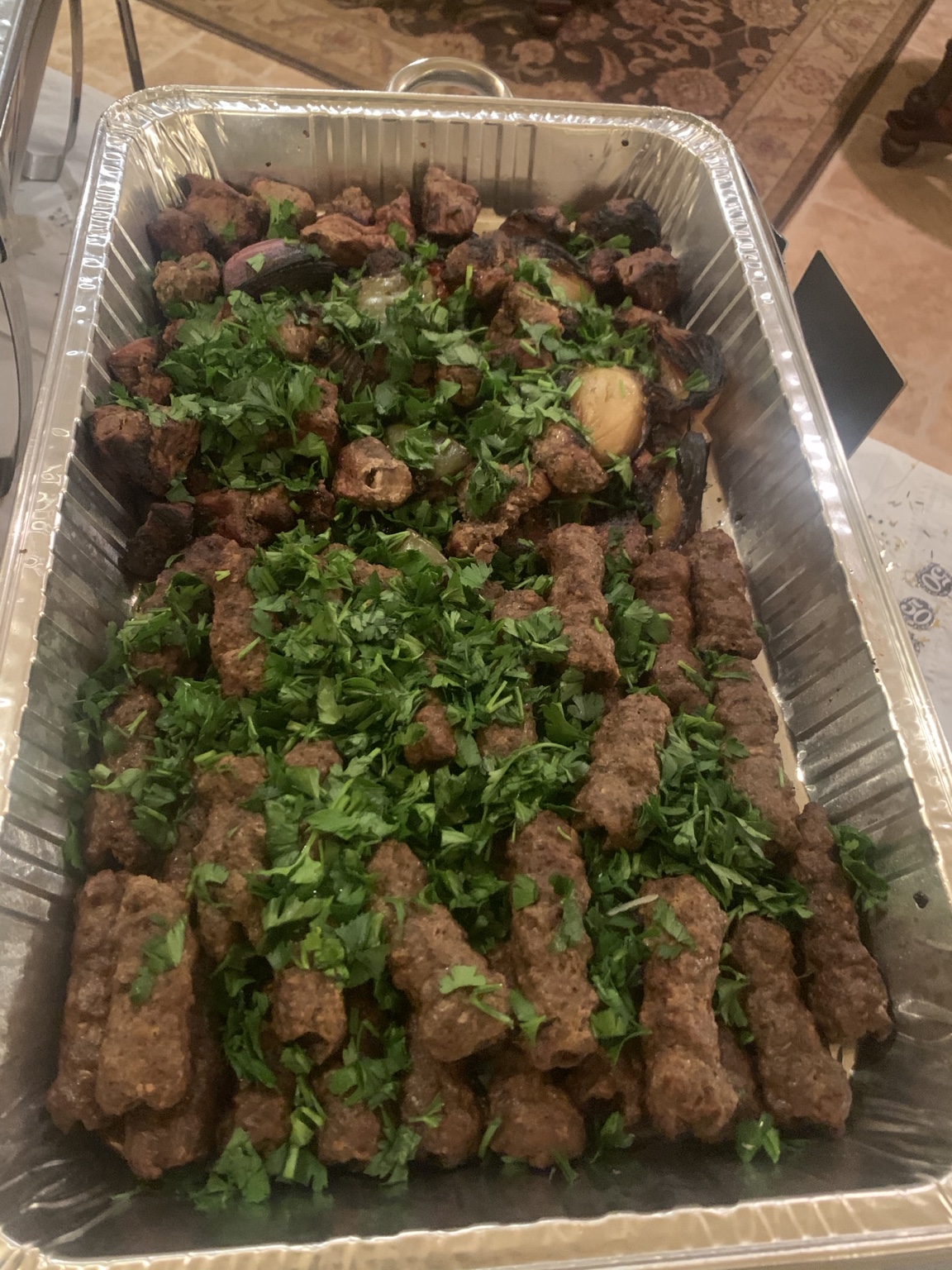 Egyptian Grill chef behind an indoor buffet of catered dishes