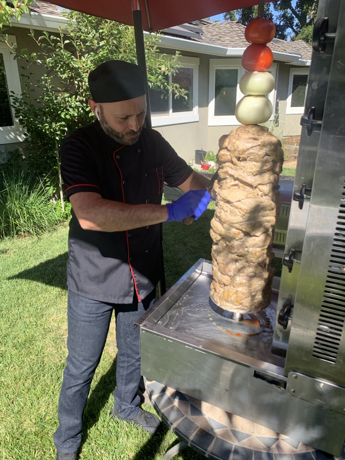 Chef preparing shawarma at an outdoor catering event