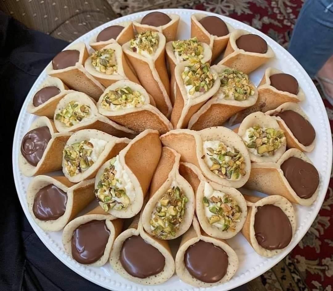 Platter of filled desserts with cream, pistachio, and chocolate